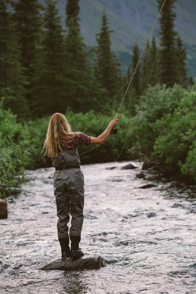 The photo shows a fly fisher women in waders